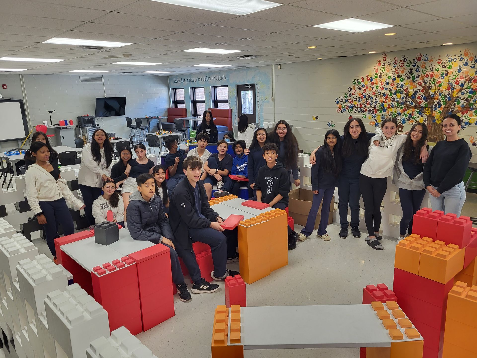 A group of young girls are sitting on the floor playing with blocks.