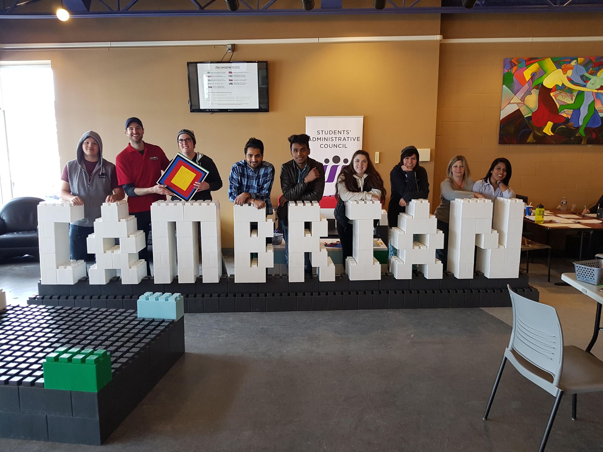 A young boy is sitting at a table playing with toys.