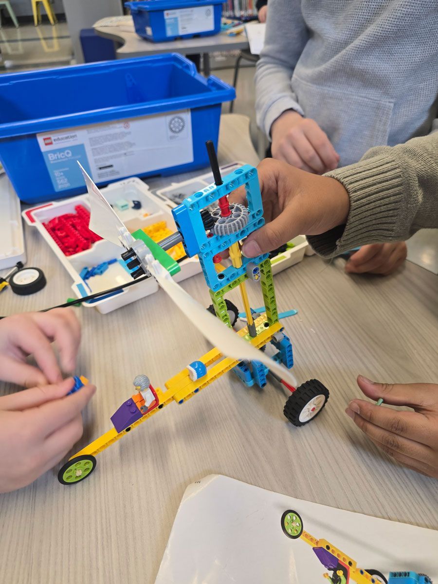 A group of children are playing with a lego airplane