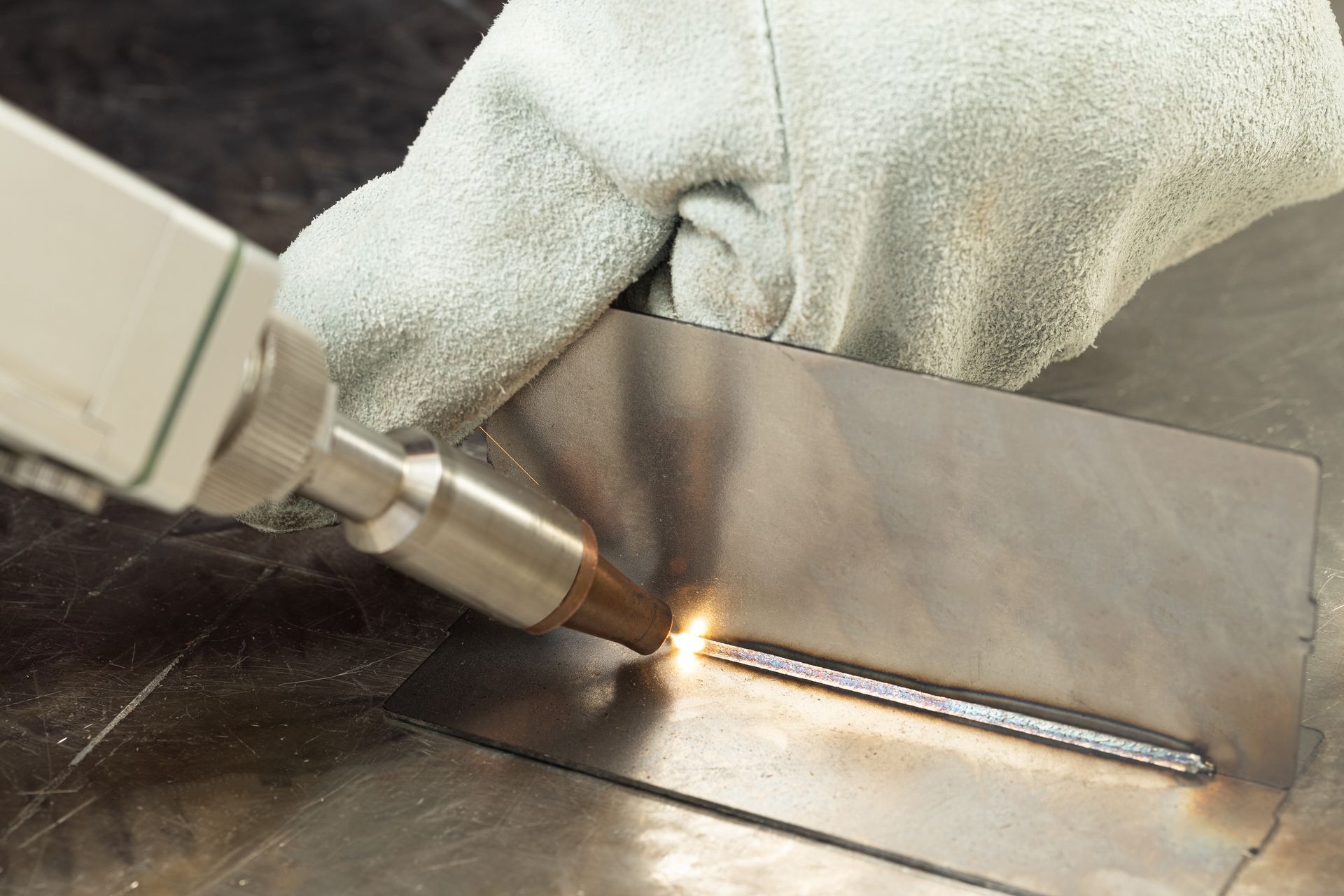 A person is welding a piece of metal