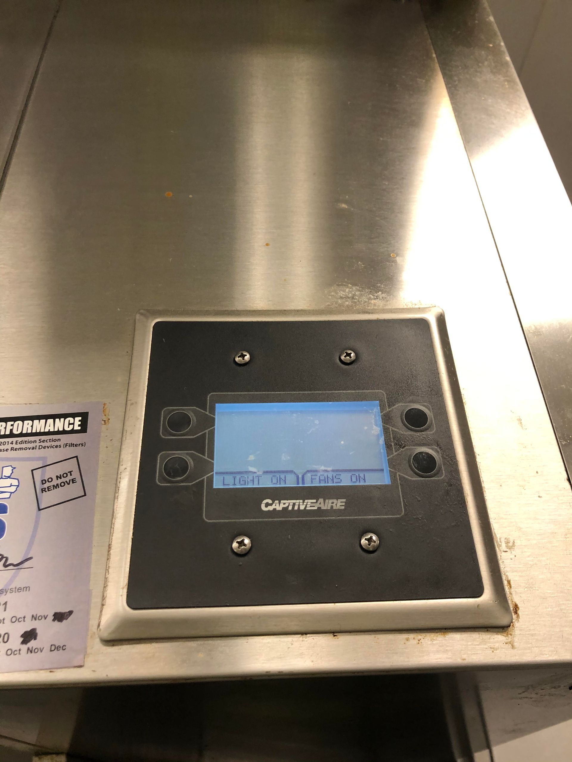 Stainless steel control panel with screen and buttons; part of a machine.