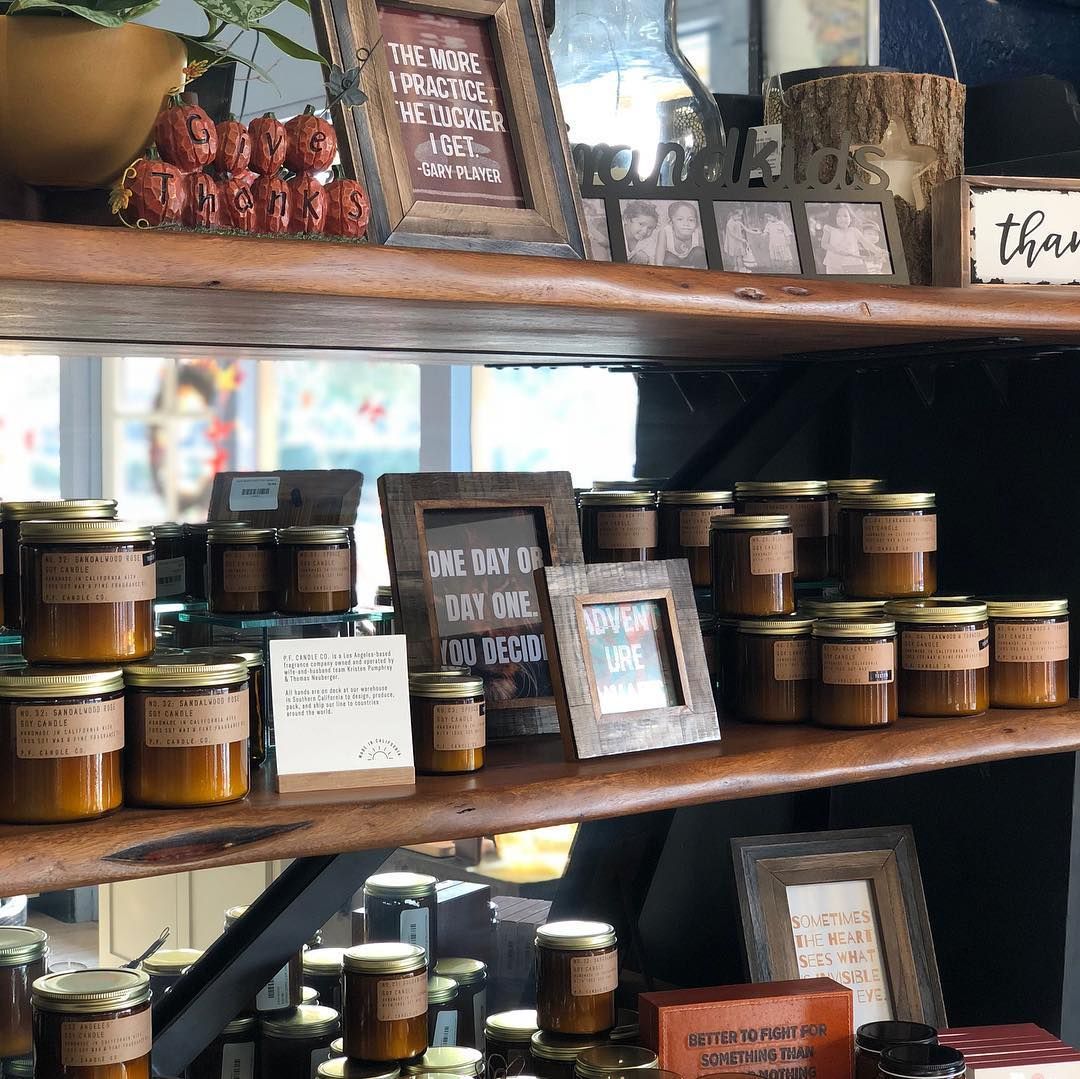 Shelves displaying jars of goods, signs, and decorative items in a store.