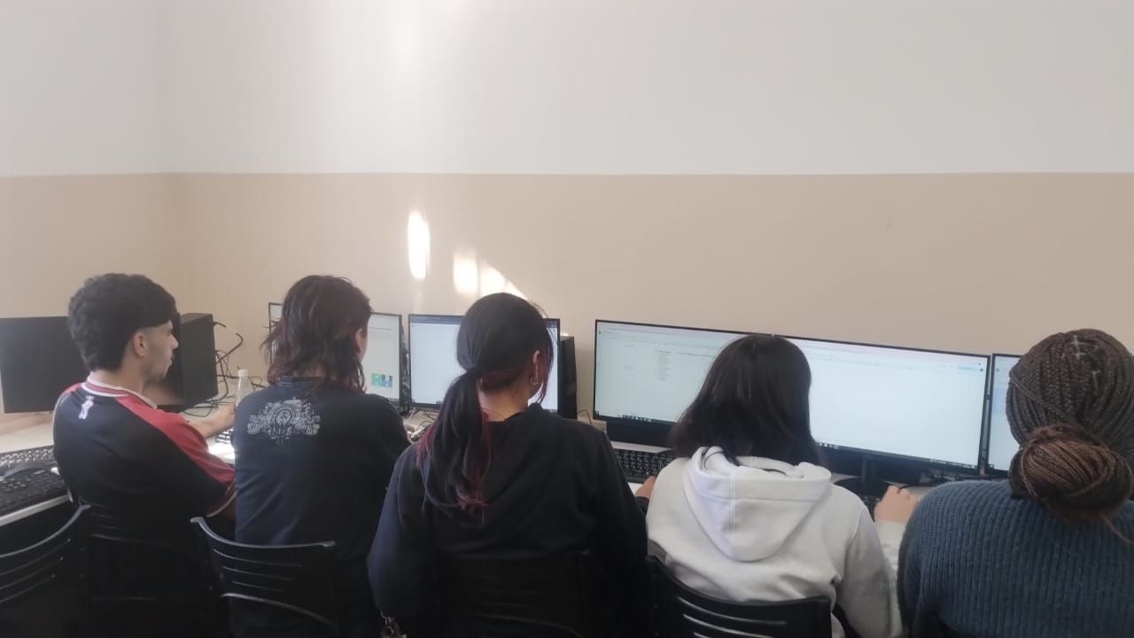 Uma mulher está fazendo uma apresentação para um grupo de alunos em uma sala de aula.