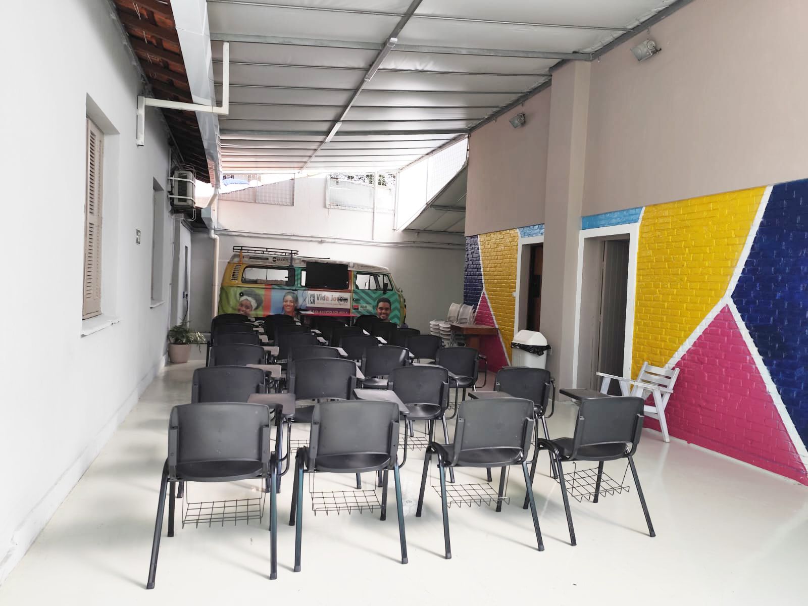 Um homem está fazendo uma apresentação para um grupo de alunos em uma sala de aula.