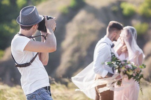 un fotografo mentre scatta foto ad una coppia di sposi