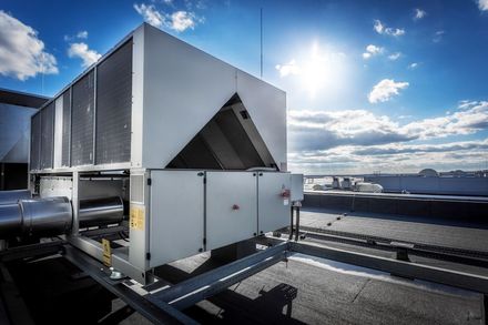 Rooftop HVAC unit against a bright blue sky. — RedJak Air Conditioning Services in Willawong, QLD