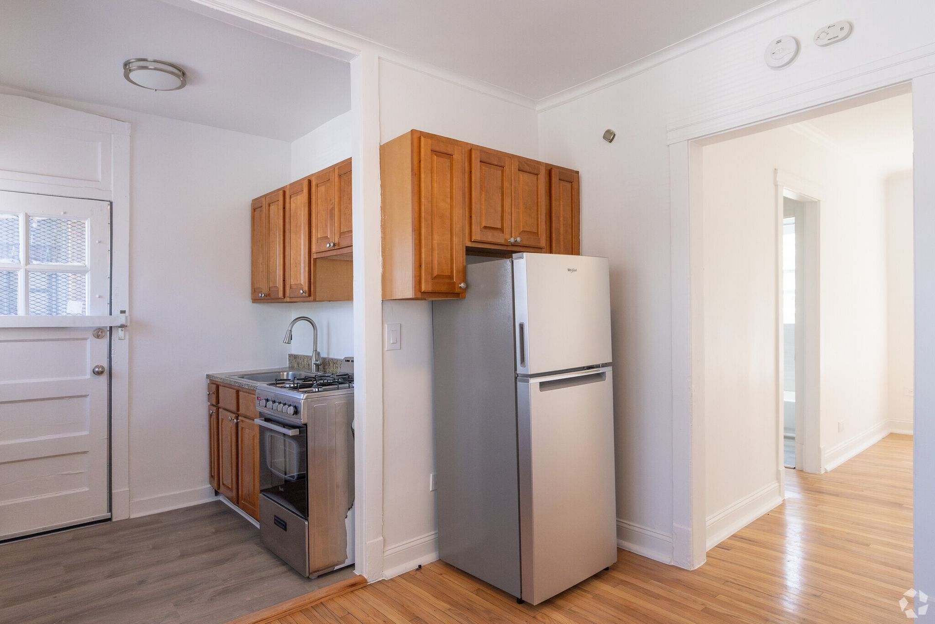 Small kitchen with light-colored cabinets, a silver refrigerator, and a stainless steel stove.