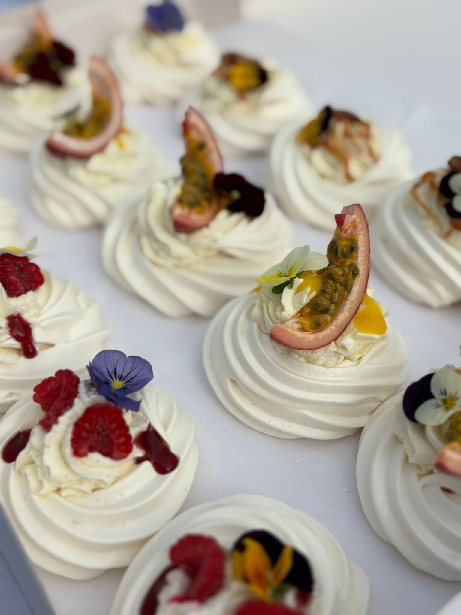 Vue en plongée d'un buffet festif composé de fruits, d'amuse-gueules sur des planches en bois, de petits sandwichs et de fleurs fraîches.