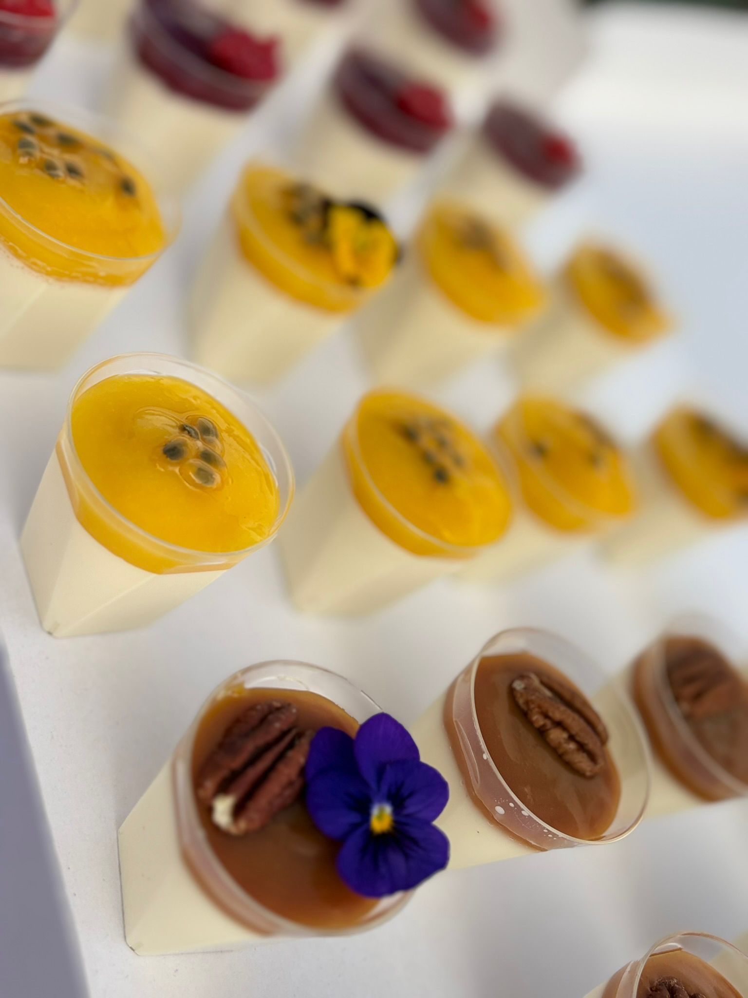 Deux distributeurs de boissons en verre sur des supports en bois, l'un rempli d'eau aromatisée aux fruits, l'autre d'eau au concombre et à la menthe.