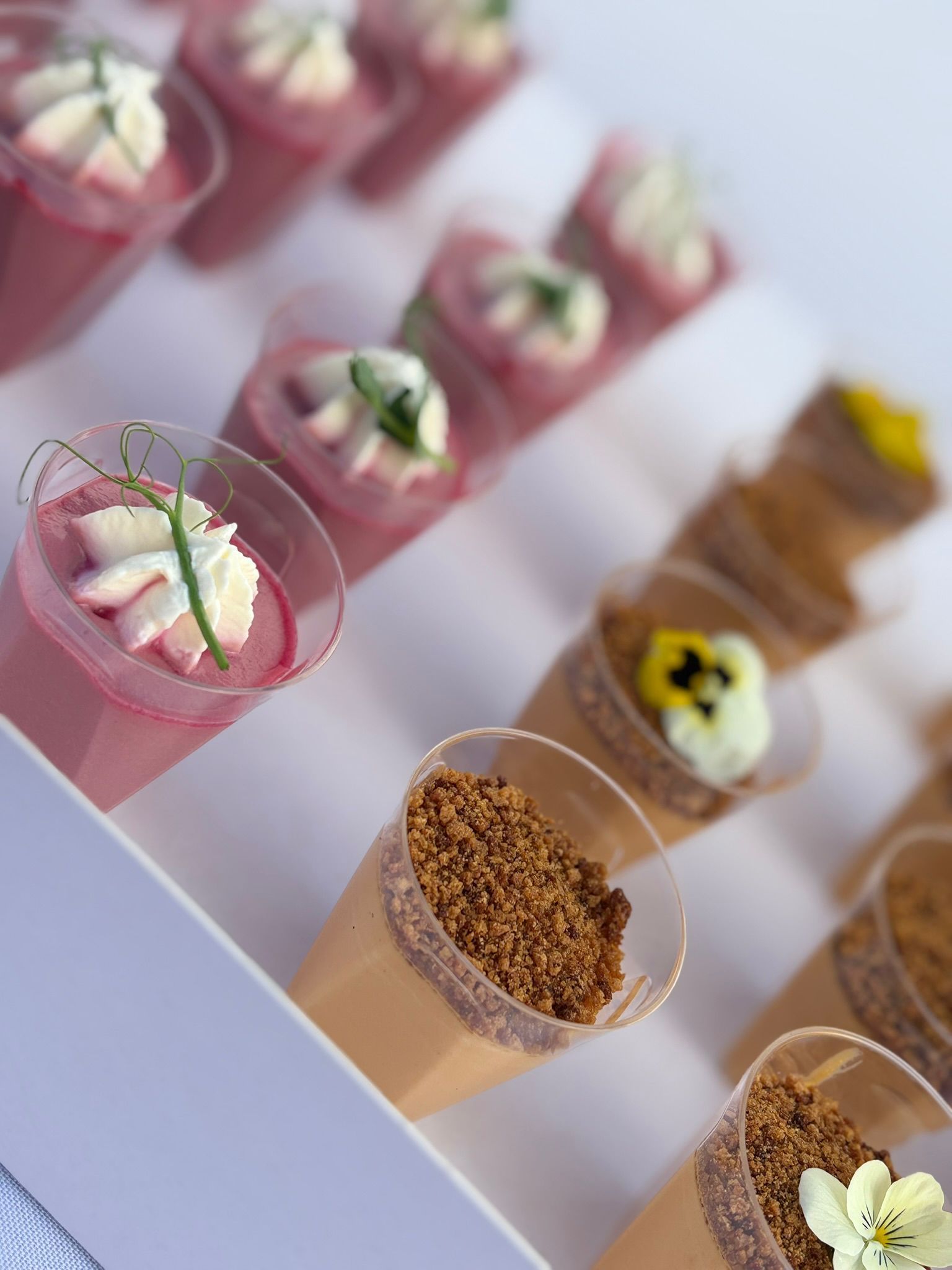 Un buffet festif proposant des mini-brochettes de crêpes garnies de baies, des croissants, des raisins et un centre de table floral éclatant.