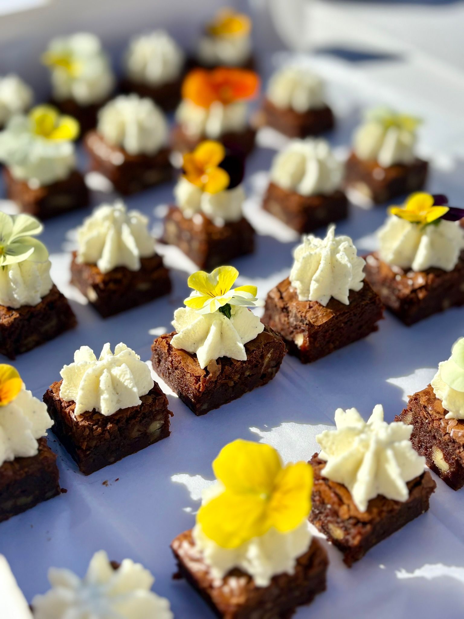 Une personne choisit un petit steak à la crème en entrée sur un plateau présenté par une personne en costume noir.