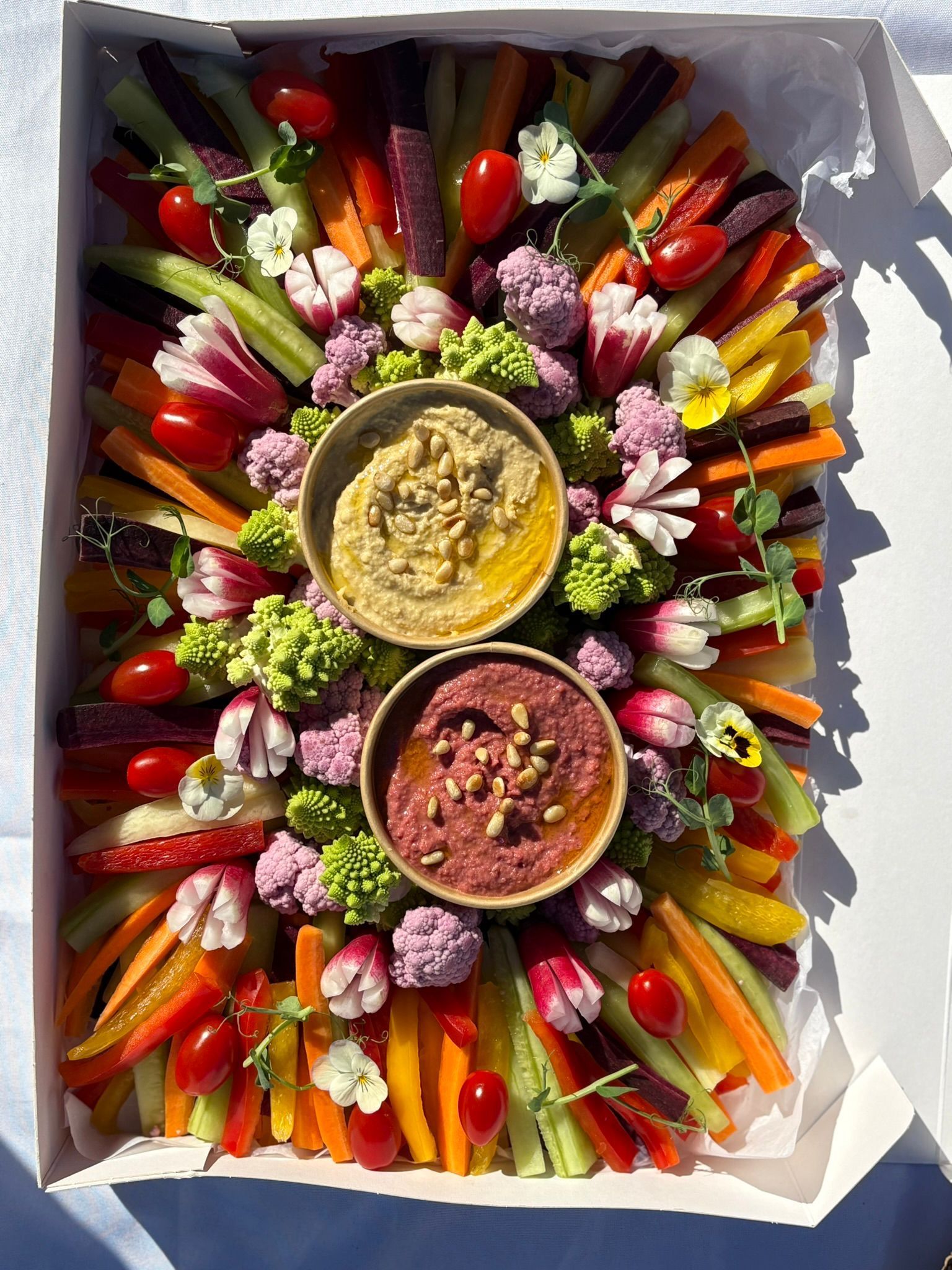 Un coffret petit-déjeuner contenant des crêpes, un gâteau aux graines de pavot, des croissants, des gaufres aux fruits et des baies fraîches.