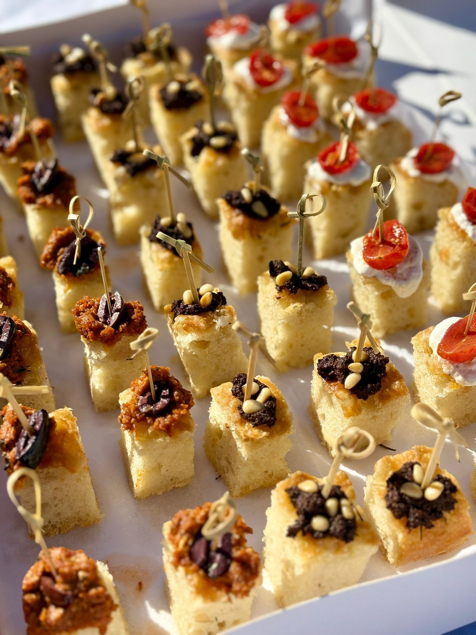 Un buffet de brunch proposant des fruits, des gaufres, des fontaines à jus et des compositions florales sur une terrasse extérieure.