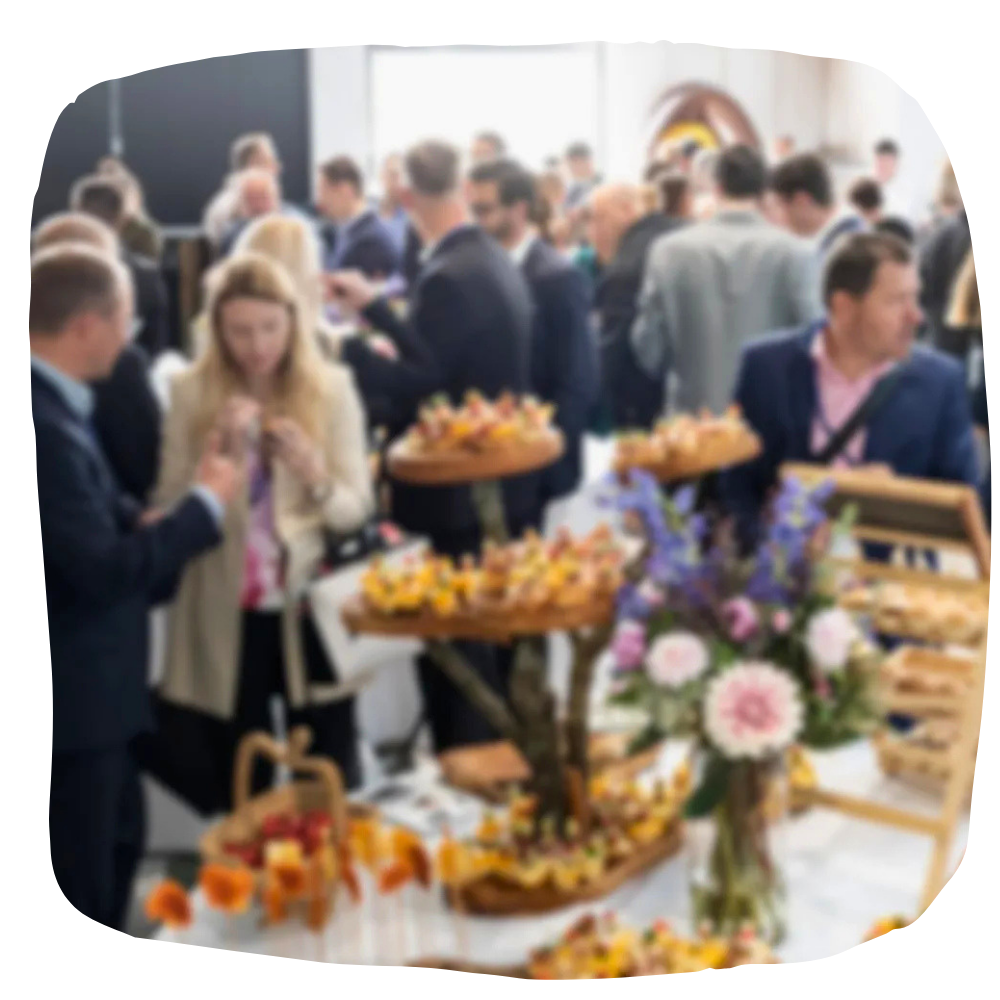 Lors d'une réception, une personne tient un plateau d'hors-d'œuvre assortis tandis qu'une autre tend la main pour en choisir un.