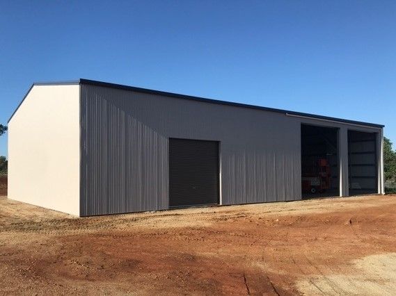 A large white metal building with a blue sky in the background.