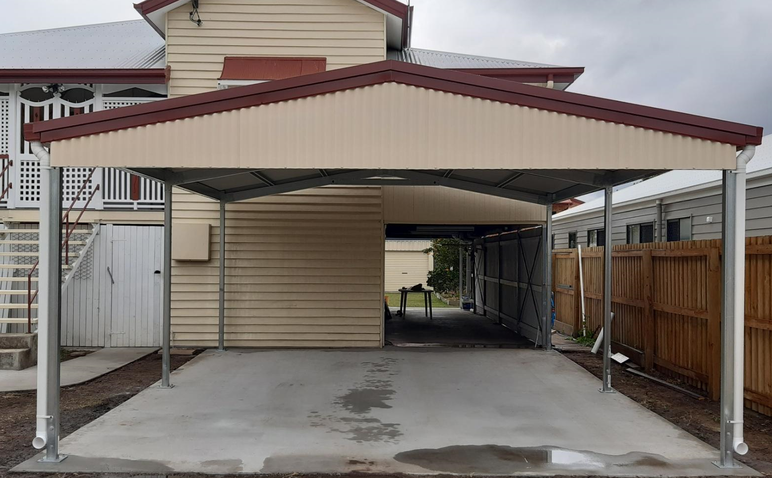 A carport is being built in front of a house.
