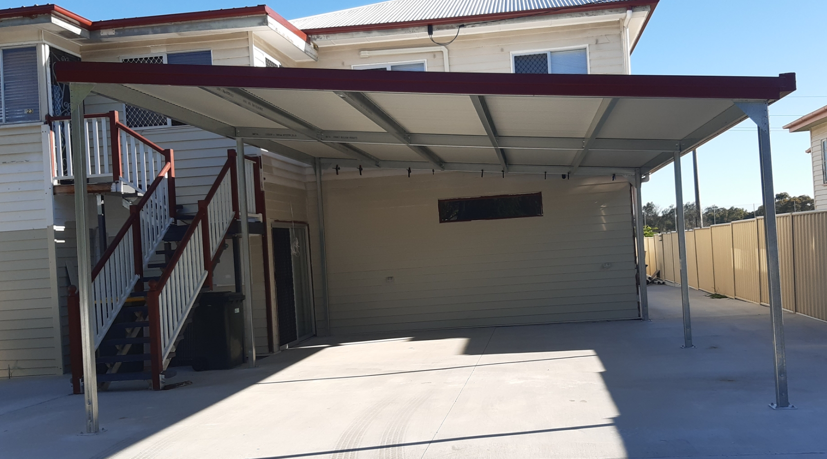 A house with a carport and stairs in front of it.