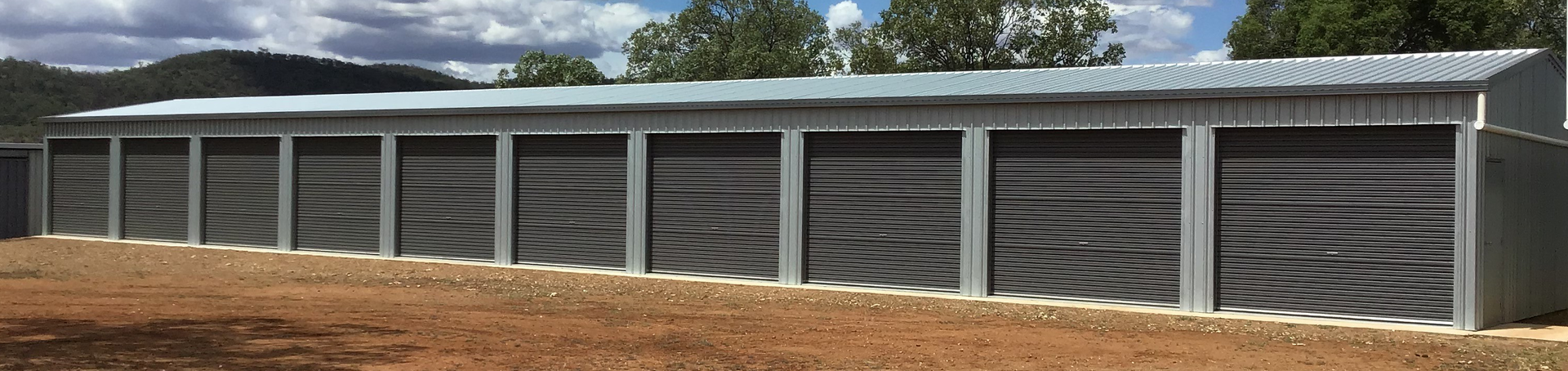 A row of garage doors are lined up in a field.