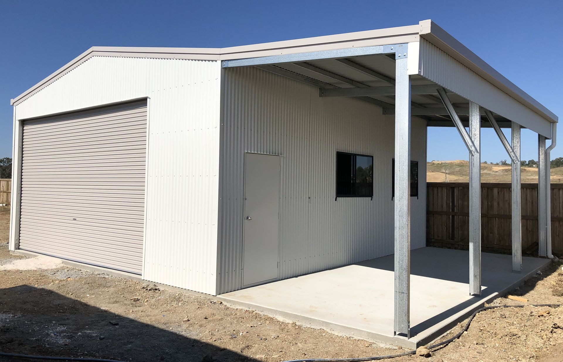 A white garage with a porch and a window.