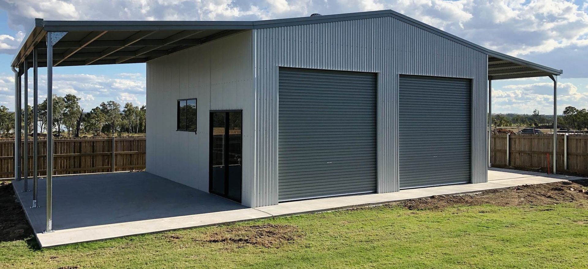 A metal garage with two garage doors and a porch.