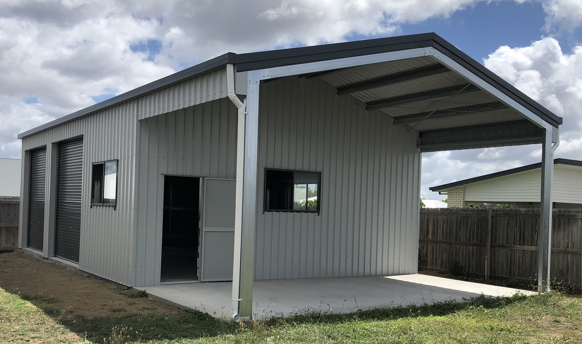 A small white building with a covered porch and a garage.