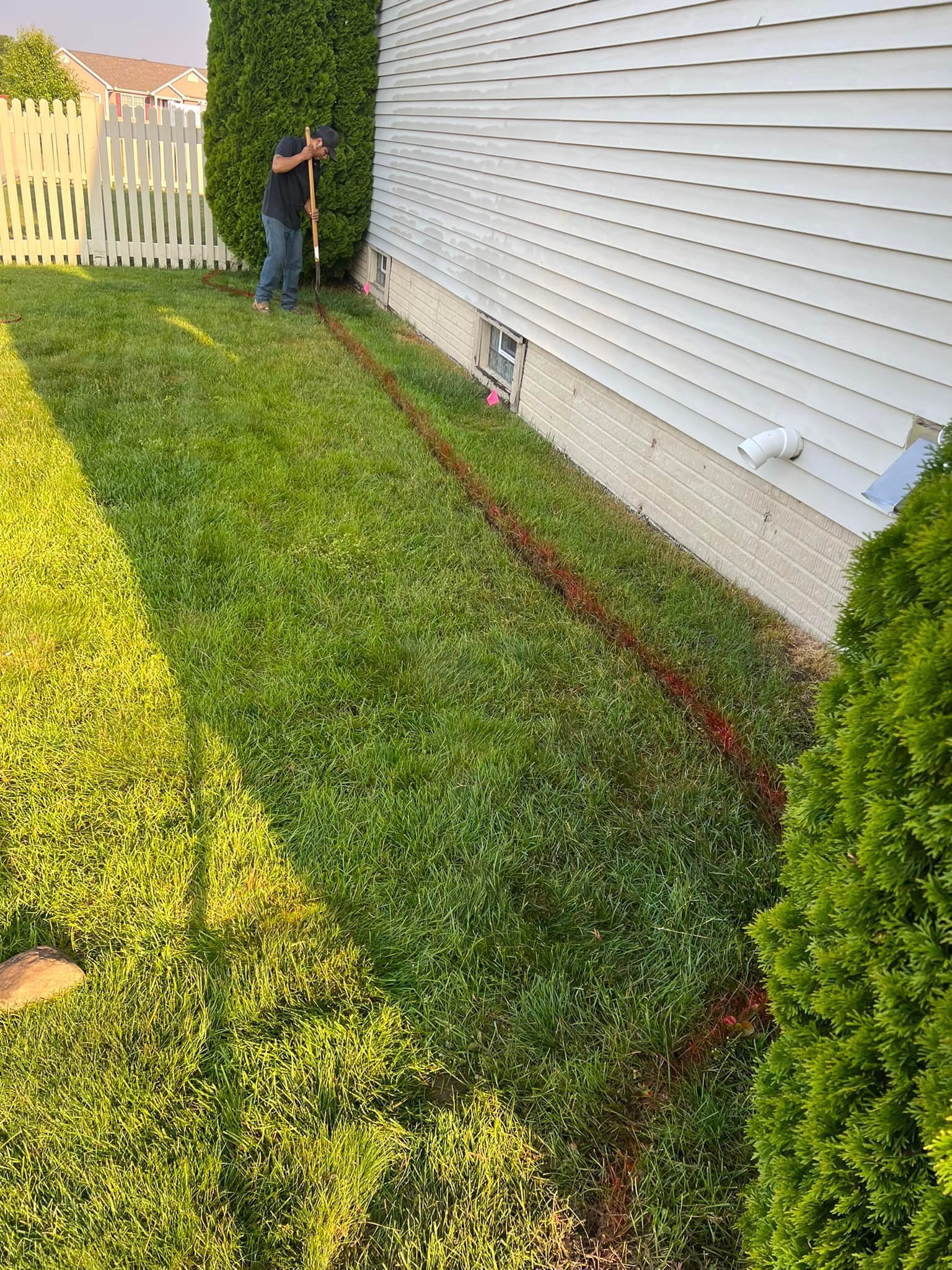 A man is standing in the grass next to a house.