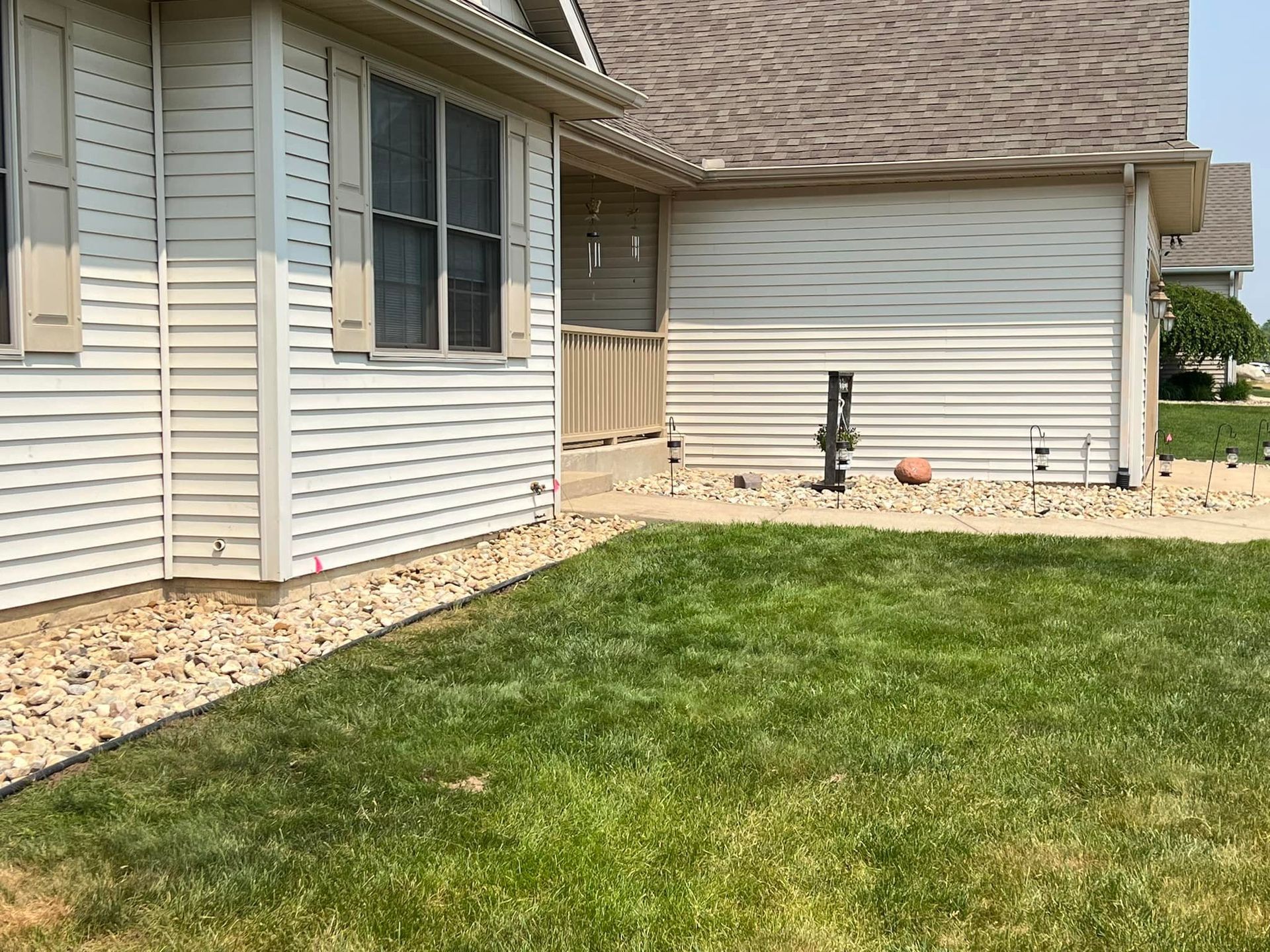 A white house with a large lawn in front of it.