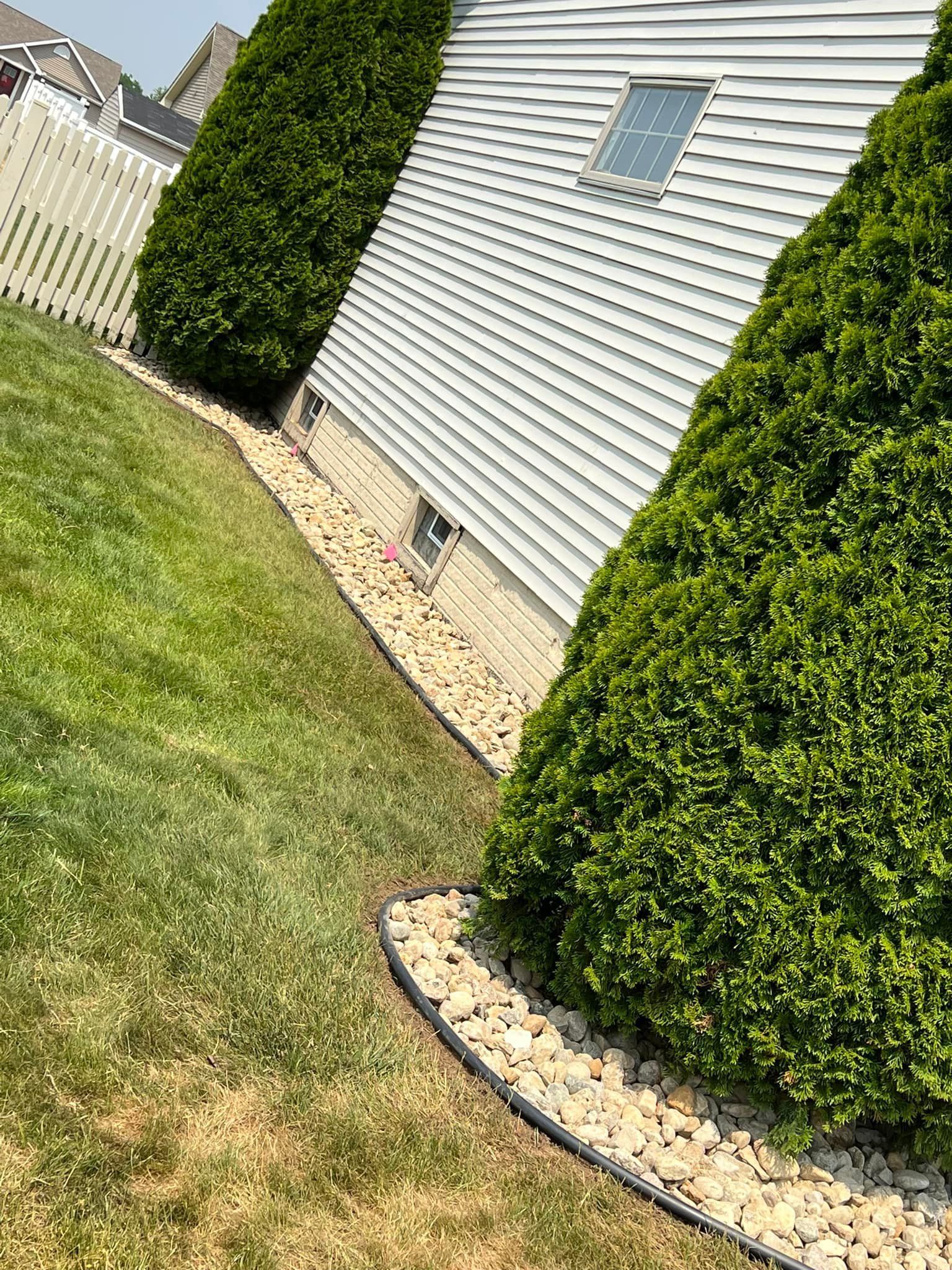 A house with a white fence and a lush green yard.