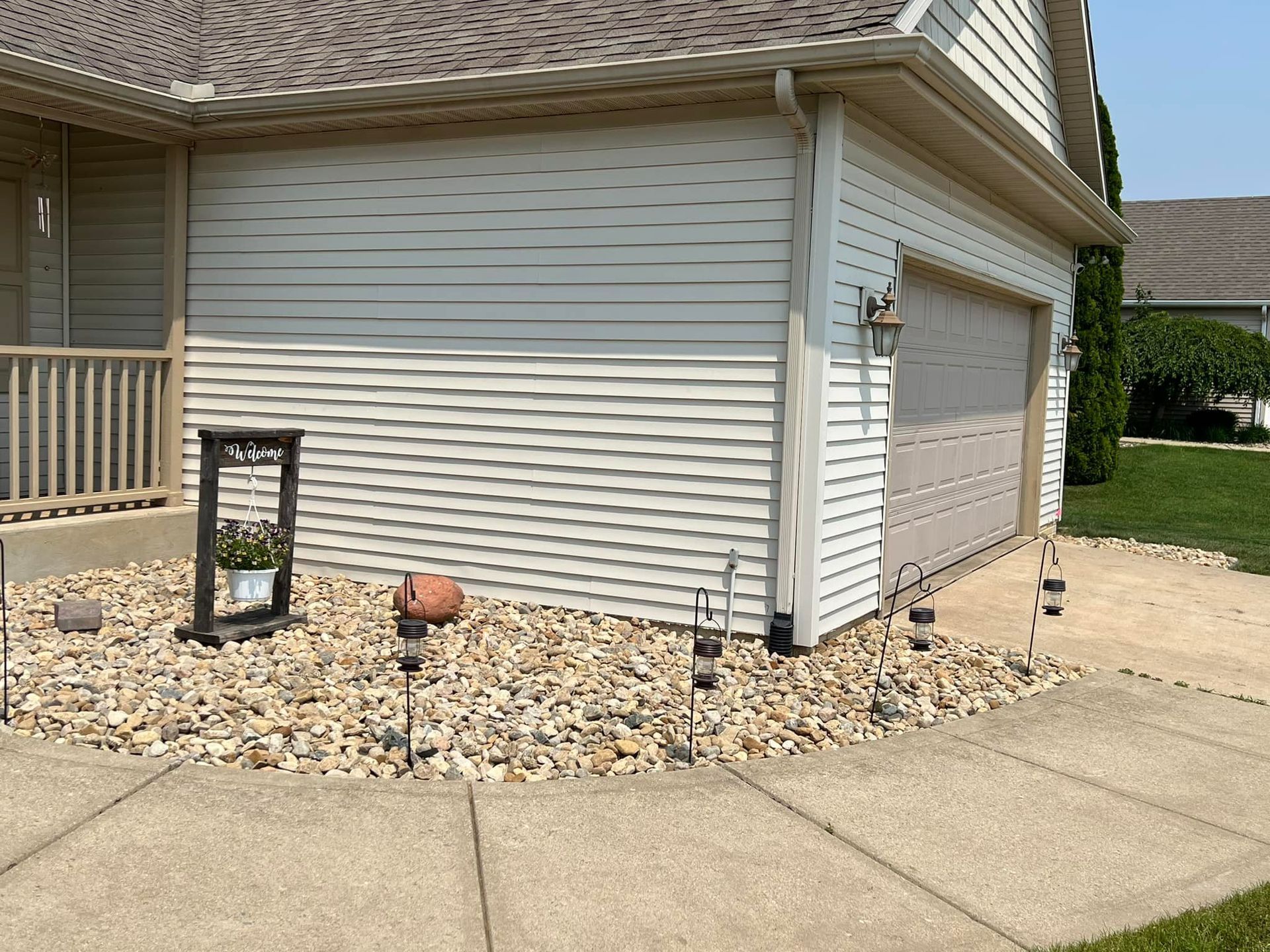 A house with a garage and a sidewalk in front of it
