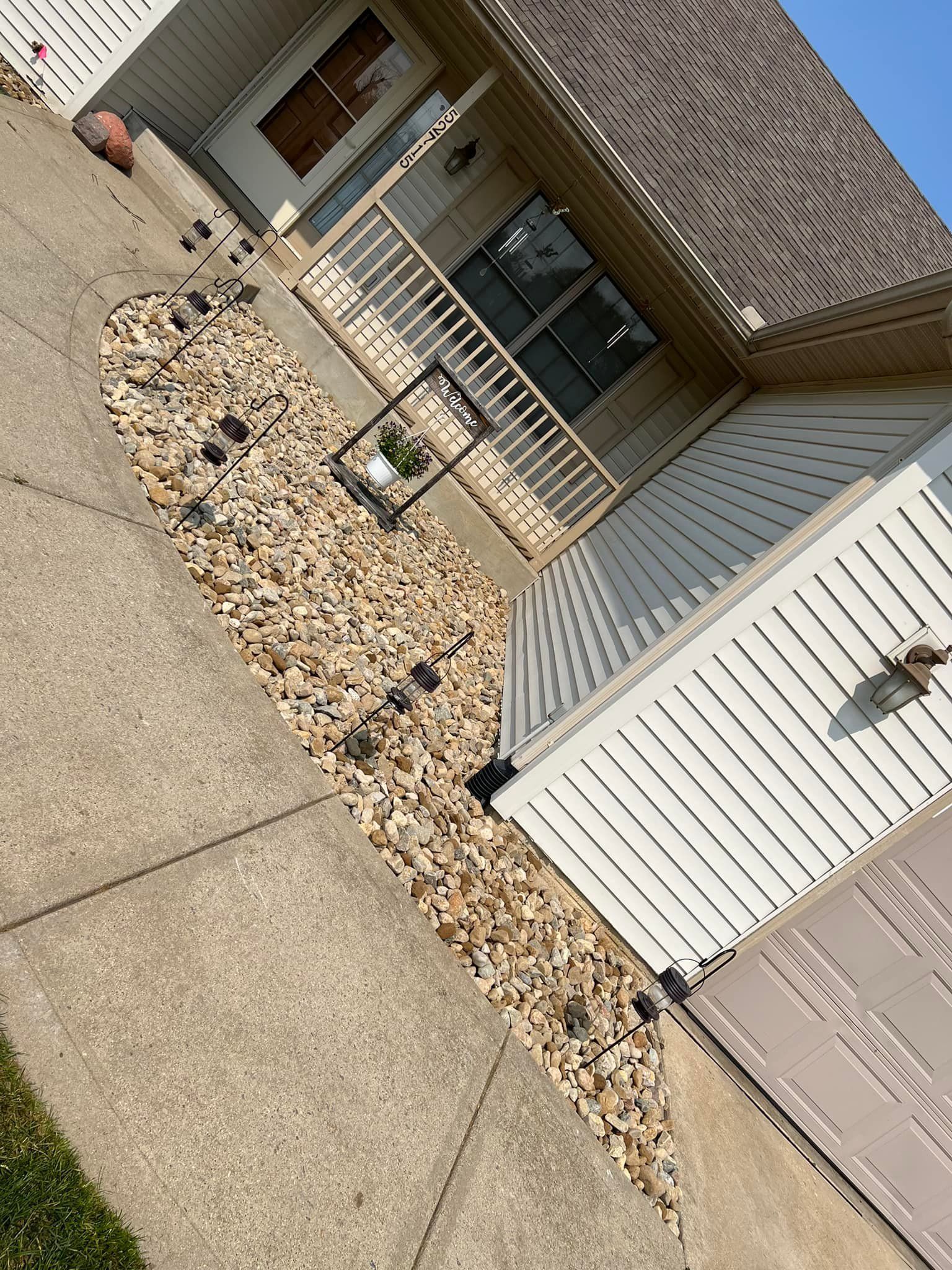 A bird is sitting on the sidewalk in front of a house.