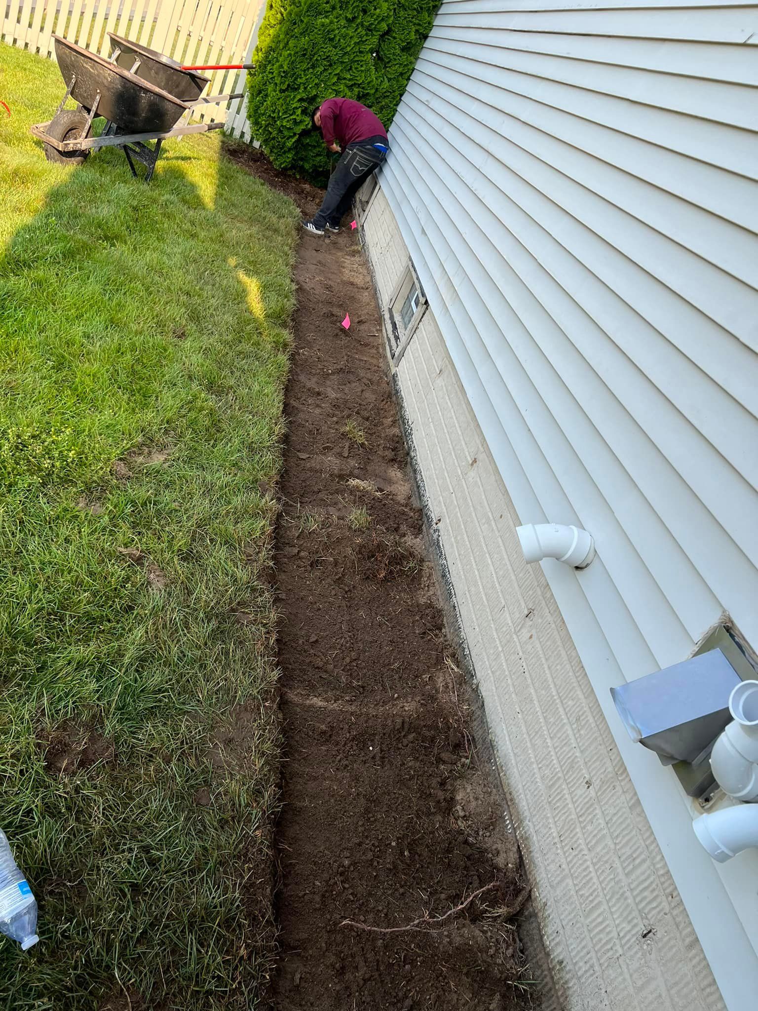 A man is digging a hole in the side of a house.