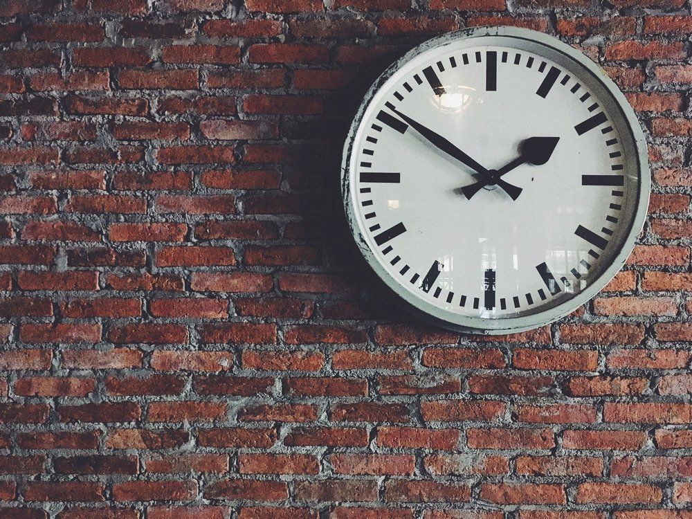 White Classic Clock on Red Brick Wall — Loans in Warners Bay, NSW