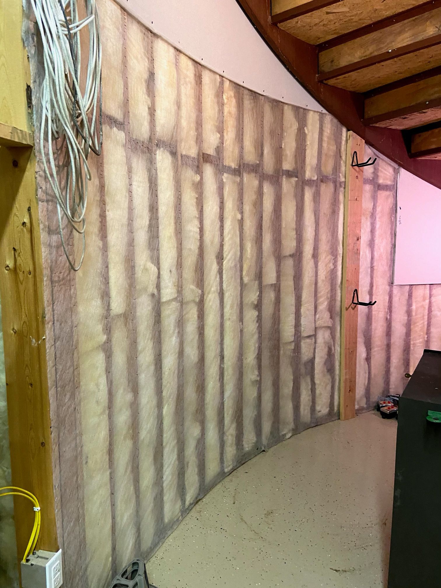 Room under construction with two ladders, doorway, and building materials.