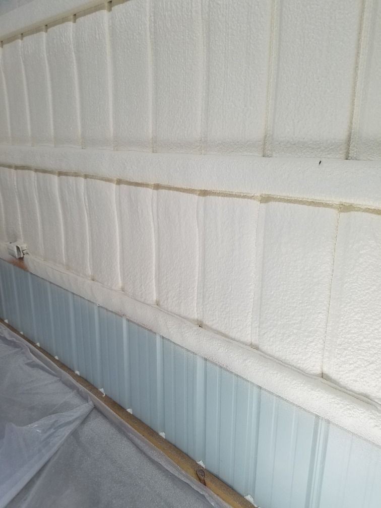 White foam insulation between metal panels, inside a building.