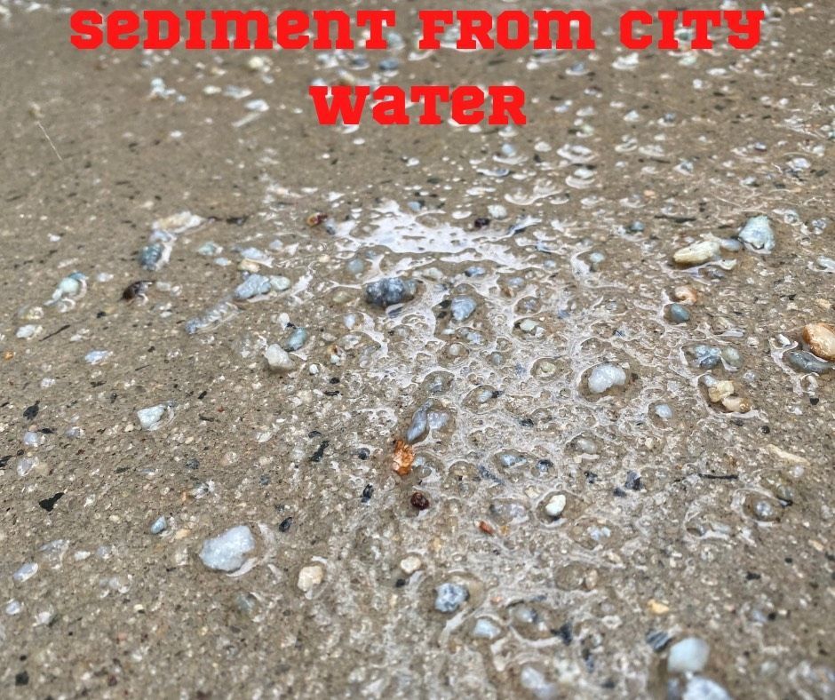 Sediment from city water is shown on a concrete surface