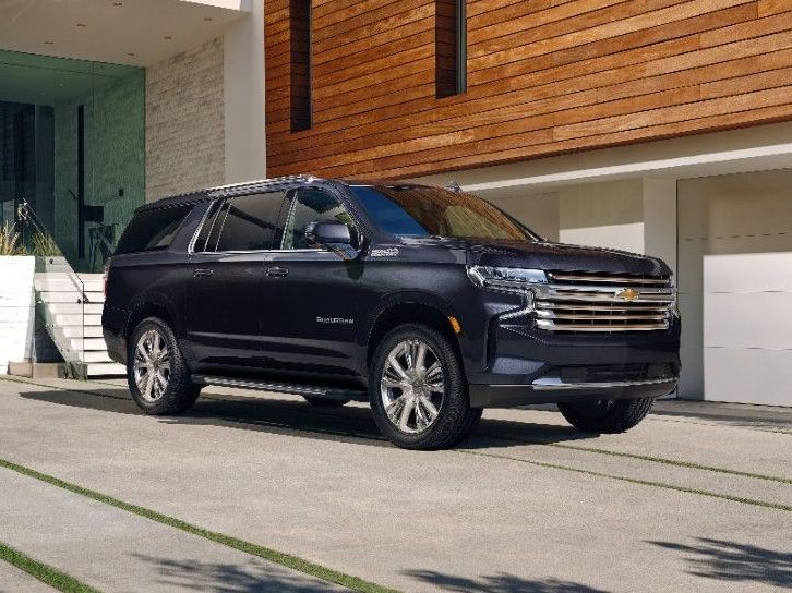 A black suv is parked in front of a house.