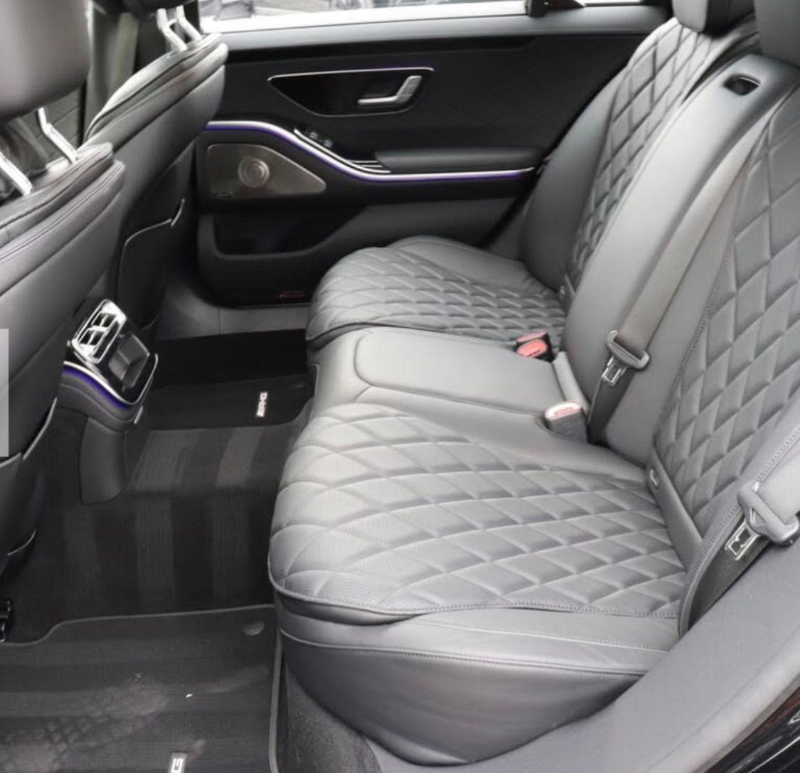 The back seat of a black car with black seats