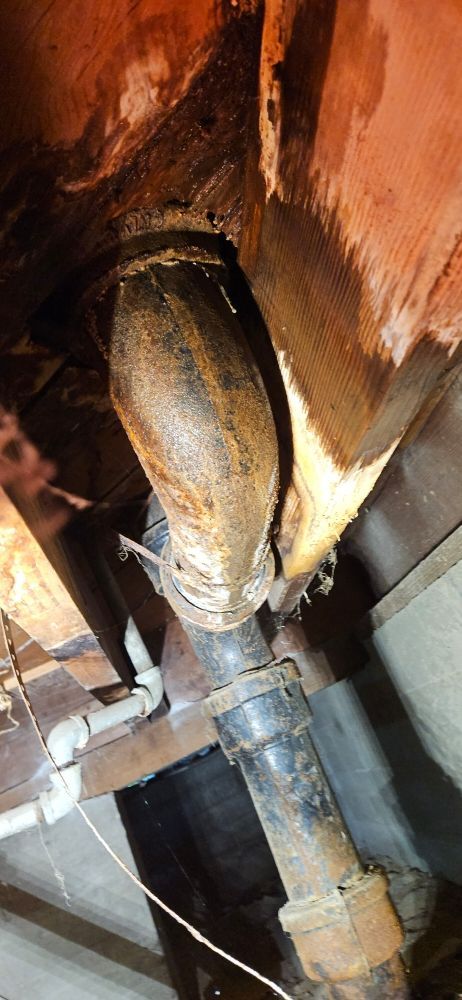 A close up of a rusty pipe in a room.