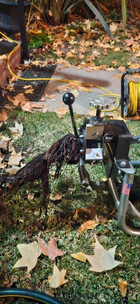 A machine is sitting on top of a lush green field surrounded by leaves.
