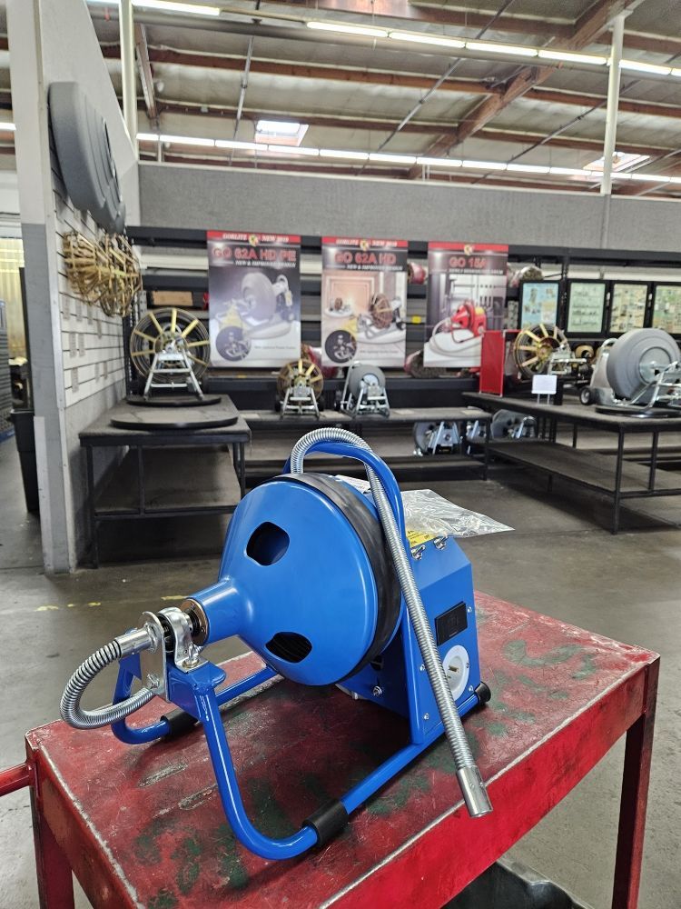 A blue machine is sitting on a red table in a warehouse.