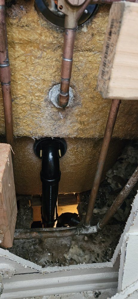 A close up of a pipe in a hole in a wall.