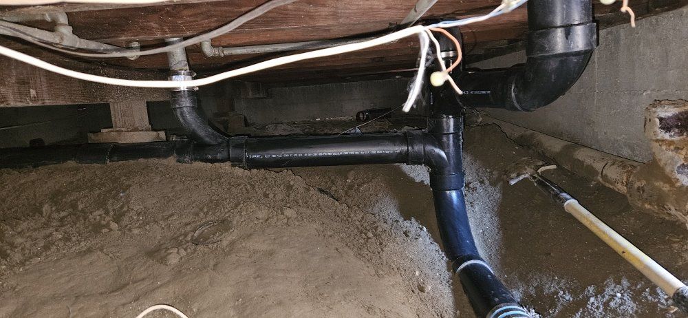 A close up of a drain pipe in a basement.