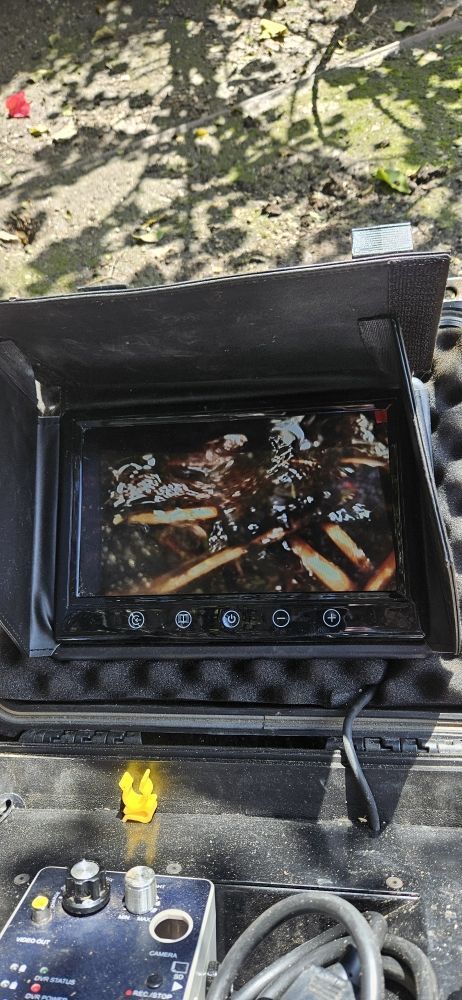 A camera is sitting on top of a table next to a steering wheel.