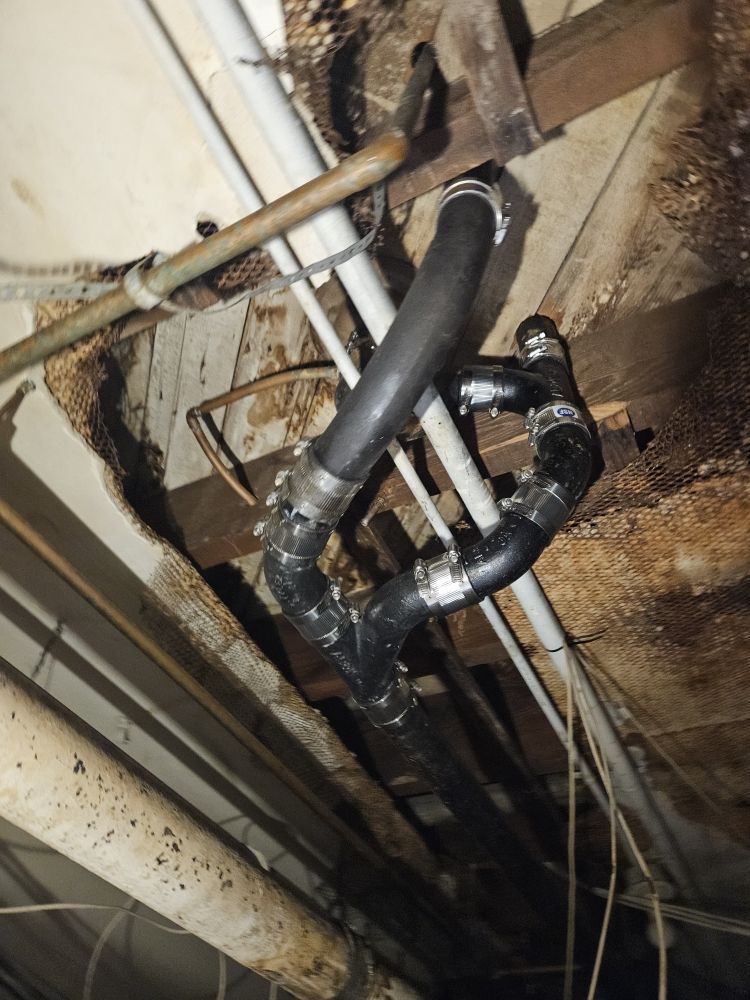 A bunch of pipes are hanging from the ceiling of a building