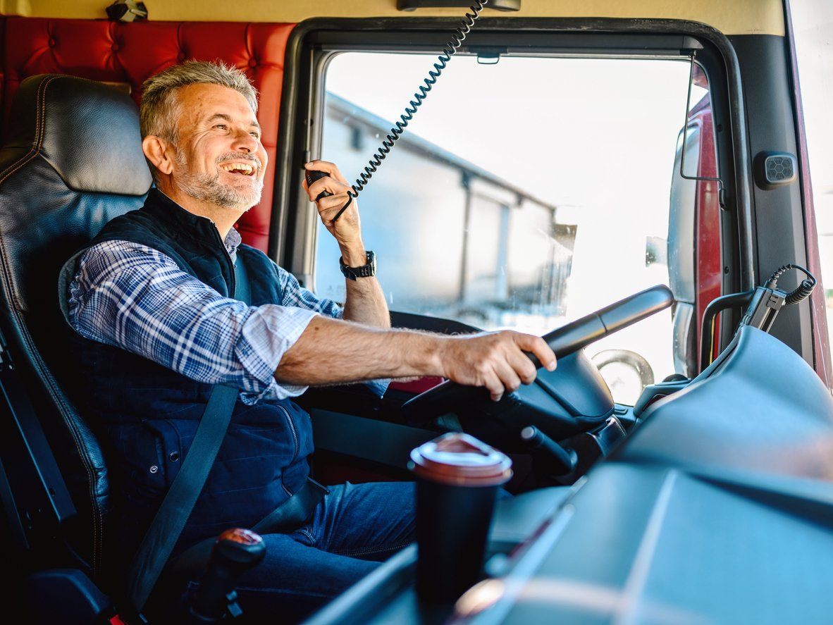 Male truck driver at work using a radio; photo showing a concept of DOT's Hours of Service Regulatio