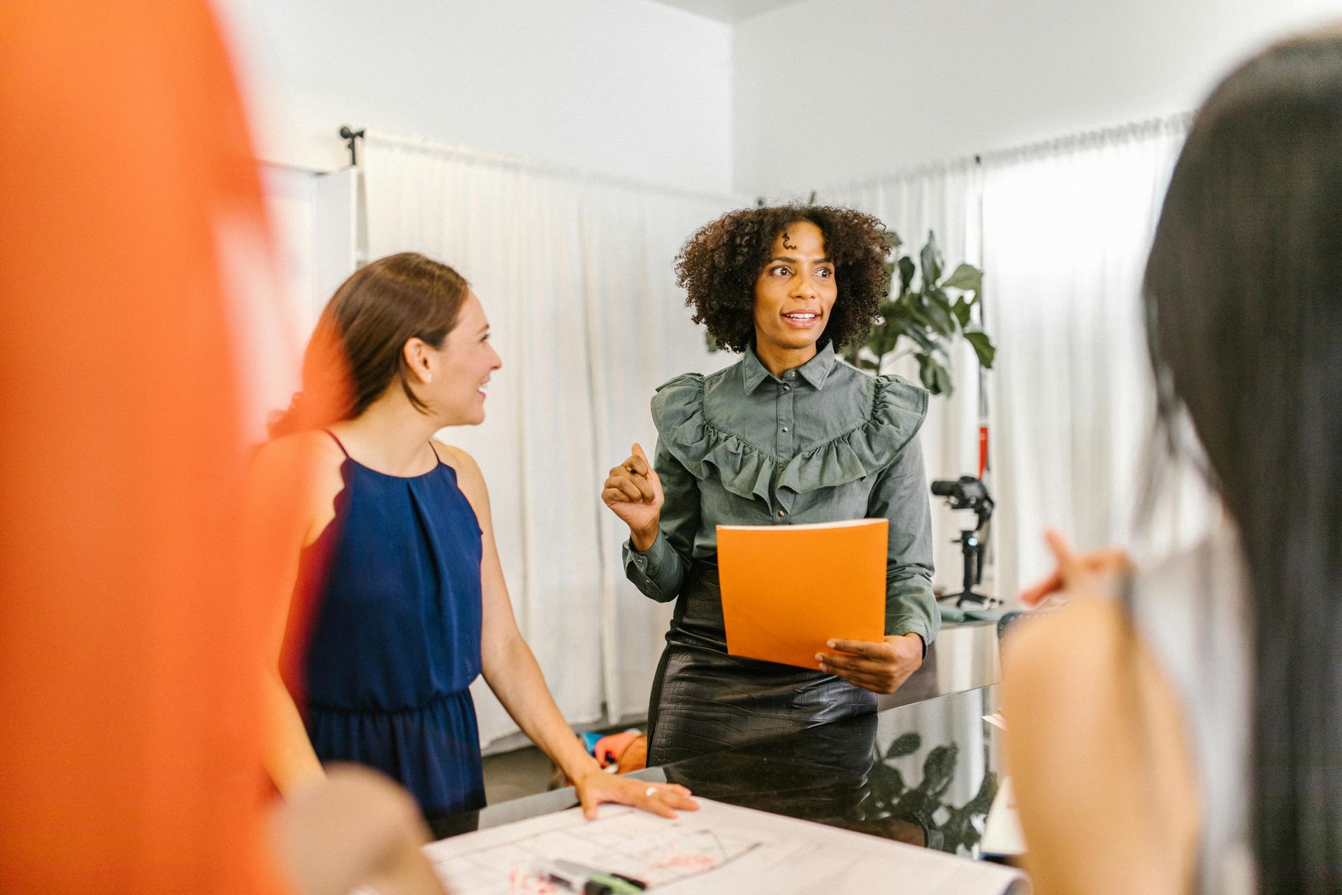 Women brainstorming and discussing ideas in a meeting, representing the creative and collaborative environment at Luxe Cosmetic Studios.