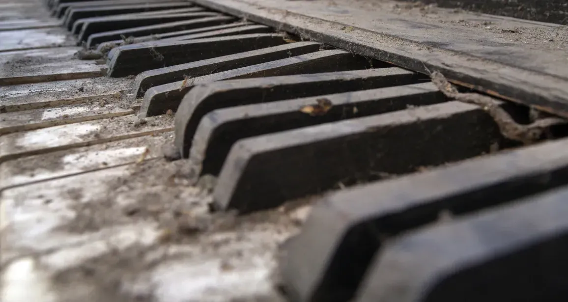 A close up of a dirty piano keyboard.