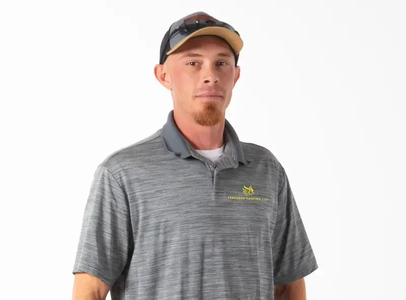 A man wearing a hat and sunglasses is standing in front of a white background.