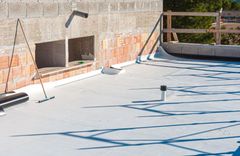 A white roof is being installed on a building under construction.