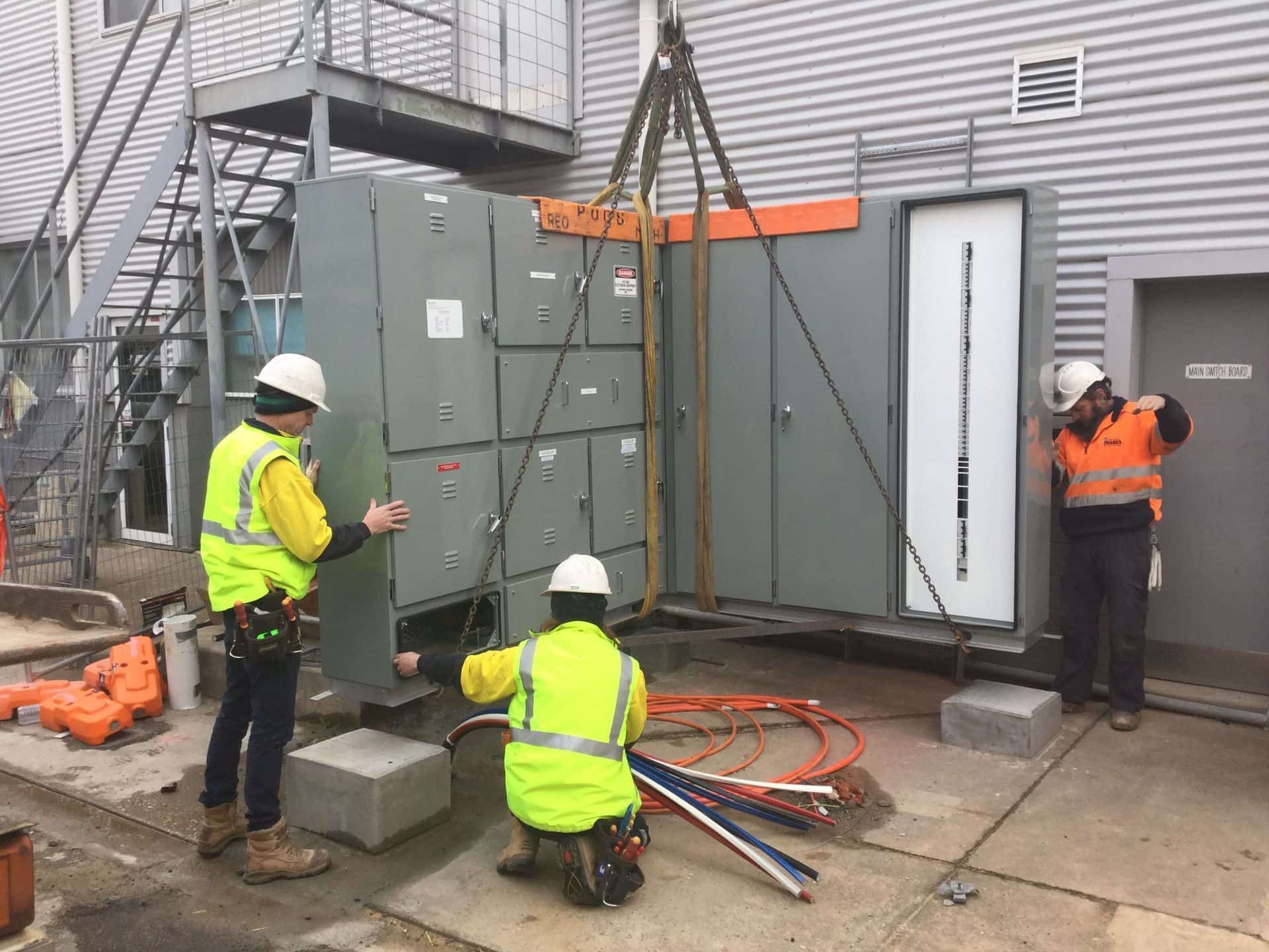 Two Workers in Safety Vests and Hard Hats Guide — Des Mullins Electrical & Solar in Wagga Wagga, NSW